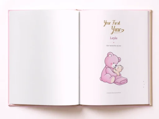 Open pink baby book at the title page “Your First Year” with the name Layla